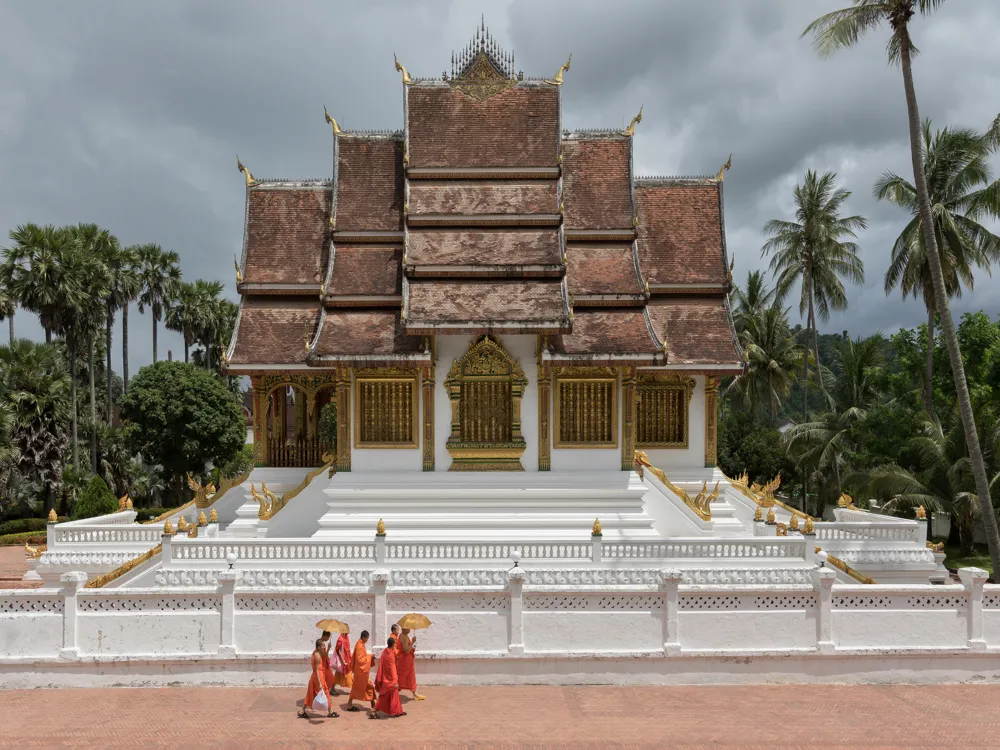 <p><strong>Monks with Umbrellas at Haw Pha Bang</strong></p>